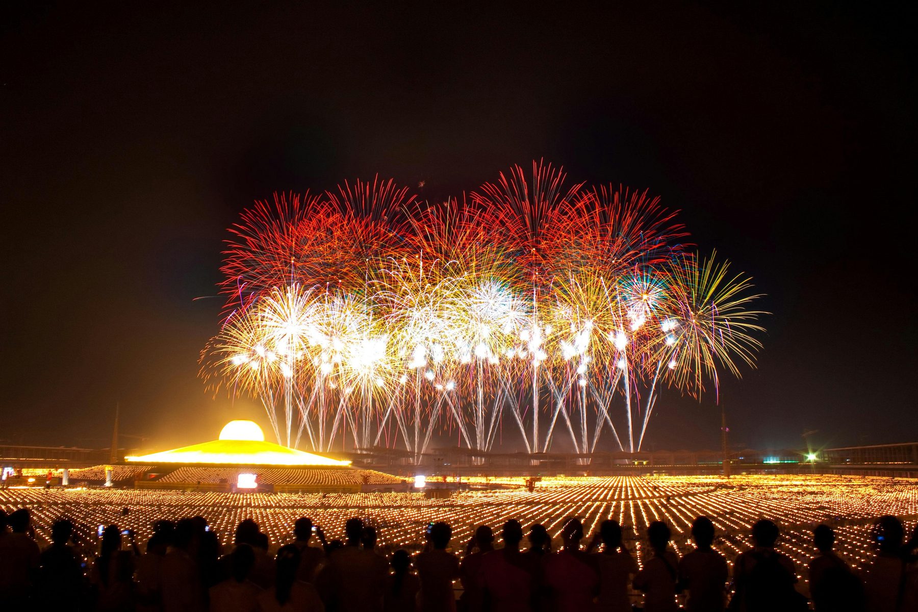 Large-scale firework display over a crowd